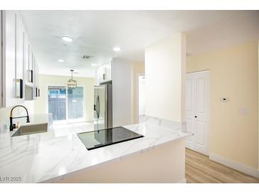 Bright kitchen featuring white cabinets, stainless steel appliances, and marble countertops at 208 N Bruce St # A, Las Vegas, NV 89101