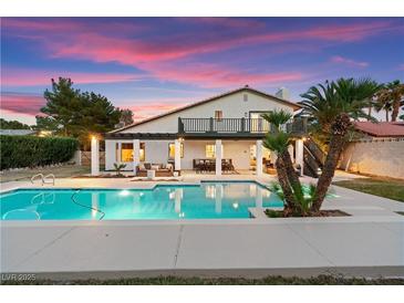 Inviting backyard pool with pristine water, mature palms, patio seating, and tranquil ambiance at 2425 Greens Ave, Henderson, NV 89014