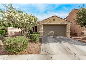 Charming single-story home featuring a two-car garage, desert landscaping, and flowering tree at 3005 Dotted Wren Ave, North Las Vegas, NV 89084