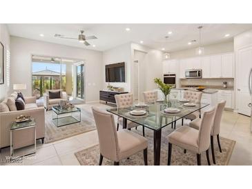 Bright, open-concept dining area with modern glass table and seating, seamlessly flowing into the kitchen and living space at 354 Spotted Dove St, Las Vegas, NV 89138