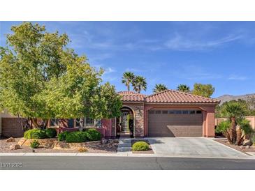Charming single-story home featuring a tile roof, landscaped yard, and a two-car garage, set against a backdrop of a bright blue sky at 7204 Royal Melbourne Dr, Las Vegas, NV 89131