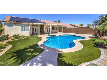 Backyard pool, patio and lawn area offer great space for outdoor living, complete with solar panels at 7489 Crystal Clear Ave, Las Vegas, NV 89113
