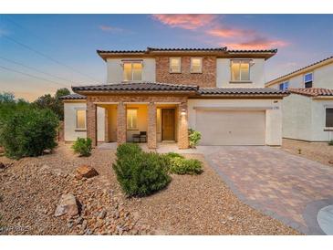 Charming two-story home featuring a brick-accented facade, covered porch, and a manicured front yard at 7931 Campers Village Ave, Las Vegas, NV 89178