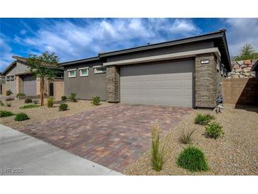 Charming single-story home with a brick driveway and stone accents at 897 Woodburn Ln, Las Vegas, NV 89138