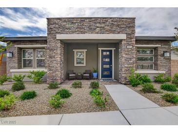 Charming single-story home with a stone facade, inviting entrance, and nicely landscaped front yard at 897 Woodburn Ln, Las Vegas, NV 89138