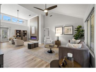 Bright living room featuring a modern fireplace, high ceilings, and an open concept design with neutral tones at 9540 Eagle Valley Dr, Las Vegas, NV 89134