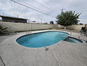 Backyard pool with lounge chairs and a mature shade tree creating a private oasis at 1338 Smoke Tree Ave, Las Vegas, NV 89108
