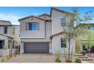 Two-story home featuring neutral paint, desert landscaping, a tile roof, and an attached two-car garage at 15 Santo Mio Ct, Henderson, NV 89011