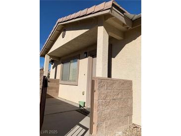 Inviting front porch featuring a secure, tan-colored block-wall surrounding the entry with stone flooring at 2050 N Los Feliz St # 114, Las Vegas, NV 89156