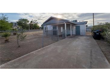 Charming single-story home with a fenced yard and covered porch, perfect for enjoying the outdoors at 211 Kansas Ave, Henderson, NV 89015