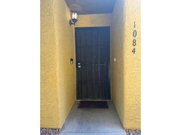 Exterior front door with black metal security screen and light fixture at 2700 N Rainbow Blvd # 1084, Las Vegas, NV 89108