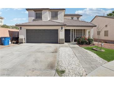 Charming two-story home featuring a two-car garage, well-maintained landscaping, and a welcoming entrance at 5220 Remini Ct, Las Vegas, NV 89130