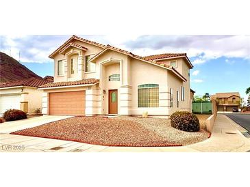 Charming two-story home with a well-manicured front yard and a two-car garage at 66 John Stuart Mill St, Henderson, NV 89002