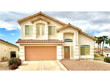 Charming two-story home with a tile roof, two-car garage, and manicured landscaping at 66 John Stuart Mill St, Henderson, NV 89002