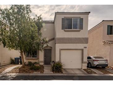 Charming two-story home with a one-car garage and neutral stucco facade, complemented by a tidy front yard and mature tree at 10049 Fragile Fields St, Las Vegas, NV 89183