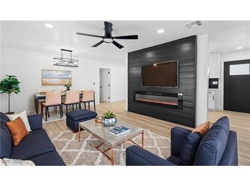 Cozy living room boasts fireplace, ceiling fan, and seamlessly connects to the dining area at 1020 Baker Ave, Las Vegas, NV 89108