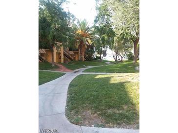 Lush green community grounds with mature trees and well-maintained pathways for a serene living environment at 1303 Darlene Way # 302C, Boulder City, NV 89005