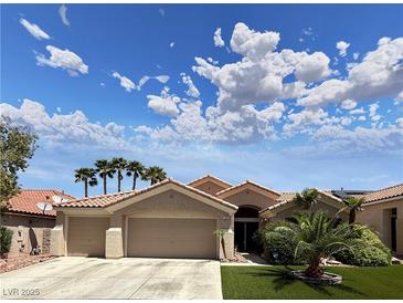 Charming single-story home featuring a two-car garage, desert landscaping and tile roof under a partly cloudy sky at 2986 Matese Dr, Henderson, NV 89052