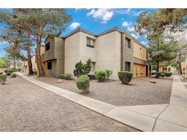 Condominium exterior with well-maintained landscaping and a neutral color palette on a bright, sunny day at 3151 Soaring Gulls Dr # 2002, Las Vegas, NV 89128