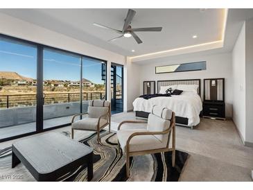 Bright bedroom with stylish decor, ceiling fan, and sliding glass doors to a patio at 36 Lakefront Dr, Henderson, NV 89011