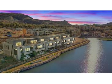 Modern waterfront home with balconies overlooks the scenic lake and mountains at sunset at 36 Lakefront Dr, Henderson, NV 89011