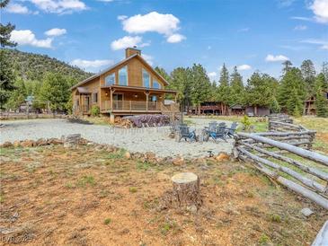 Charming wooden cabin with a covered porch and outdoor seating area at 855 E Ponderosa Rd, Mammoth Creek, UT 84735
