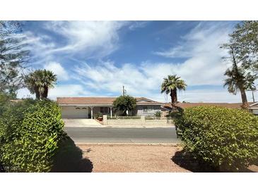 Charming single-story home featuring a well-maintained yard with palm trees and a white fence at , Las Vegas, NV 89121