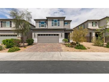 Charming two-story home featuring a gray color scheme, complemented by a well-manicured lawn and a two-car garage at 1004 Huckburn Ave, Henderson, NV 89015