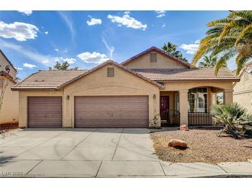 Charming single-story home featuring a three-car garage, desert landscaping, and a terracotta tile roof at 9530 Redstar St, Las Vegas, NV 89123