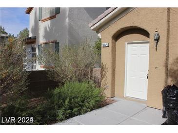 Inviting front entrance to home with neutral stucco, manicured bushes, and a covered entryway at 10021 Via Toro Ave, Las Vegas, NV 89117