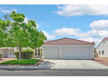 Charming home featuring a red tile roof, two-car garage, well-maintained lawn and mature landscaping at 2011 Mountain Sunset Ave, North Las Vegas, NV 89031