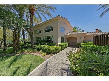 Beautiful home with lush landscaping, mature palm trees, and a charming stone pathway at 2050 W Warm Springs Rd # 2822, Henderson, NV 89014