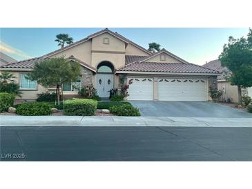 Charming single-story home featuring a lush front yard, stone accents, and a two-car garage at 2559 Purple Heather Pl, Henderson, NV 89052
