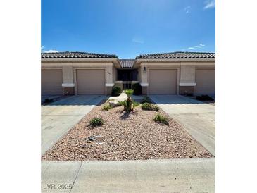 Charming single-story home featuring desert landscaping, a covered entry, and attached two-car garages at 3263 Quail Song Dr, Laughlin, NV 89029