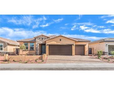Charming single-story home featuring a three-car garage, stone accents, and a well-maintained front yard under a bright sky at 522 Copper Falcon Ave, Henderson, NV 89011