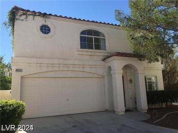 Charming two-story home featuring a red tile roof, arched window, and attached two car garage at 8829 Cornwall Glen Ave, Las Vegas, NV 89129