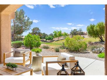 Relaxing patio area with outdoor seating and a view of the lush green landscape at 10557 Shoalhaven Dr, Las Vegas, NV 89134