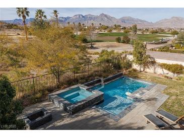 Inviting backyard featuring a sparkling pool, spa, and mountain views, perfect for outdoor relaxation and entertainment at 2215 Alcova Ridge Dr, Las Vegas, NV 89135