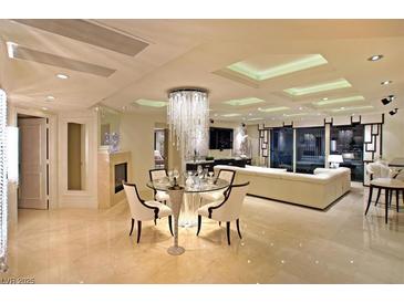 Elegant living room featuring a modern fireplace and a luxurious chandelier above the glass dining table at 2747 Paradise Rd # 1703, Las Vegas, NV 89109