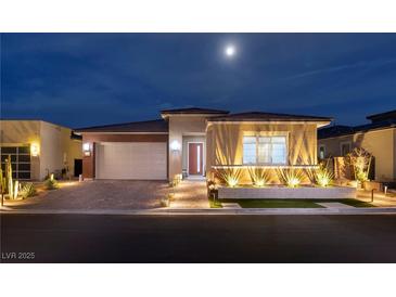 Charming single-story home featuring manicured landscaping and a brick-accented two-car garage under a moonlit sky at 3000 Dusky Willow Ln, Las Vegas, NV 89138
