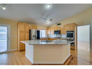 Bright kitchen features stainless appliances, granite countertops, and a central island at 6582 Cartgate Ct, Las Vegas, NV 89110