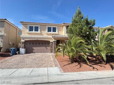 Charming two-story home featuring a brick driveway, stone accents, and mature landscaping at 6778 Goose Watch Ct, Las Vegas, NV 89139