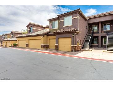 Townhouse exterior showcasing a row of units with attached garages and staircase access, offering convenient parking and entry at 6868 Sky Pointe Dr # 1122, Las Vegas, NV 89131