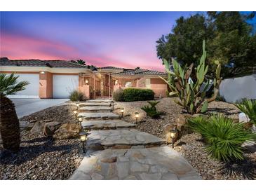 Charming home featuring a stone pathway with solar lighting and desert landscaping at 8216 W Hammer Ln, Las Vegas, NV 89149