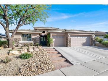 Beautiful single-story home with stone accents, well-manicured landscaping, and an attached two-car garage at 10309 Canyon Valley Ave, Las Vegas, NV 89145