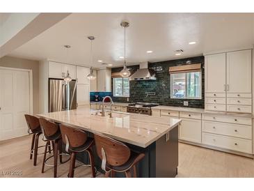 Bright eat-in kitchen with large marble island, stainless steel appliances, and green tile backsplash at 1712 Chapman Dr, Las Vegas, NV 89104