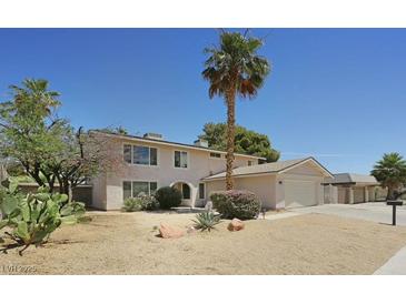 Two-story home featuring desert landscaping, a palm tree, attached garage, and driveway at 3886 Green Leaf Dr, Las Vegas, NV 89120