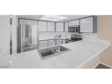 Modern kitchen featuring stainless steel appliances, quartz countertops, and grey and white cabinets at 6250 W Flamingo Rd # 51, Las Vegas, NV 89103