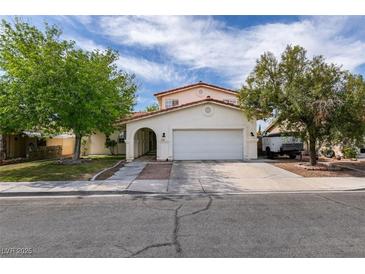 Charming single-Gathering home featuring desert landscaping, a two-car garage, and an inviting arched entryway at 7409 Central Butte Ave, Las Vegas, NV 89129