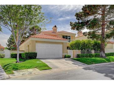 Charming two-story home with a red tile roof, attached two-car garage, and manicured landscaping in a suburban neighborhood at 8221 Crow Valley Ln, Las Vegas, NV 89113